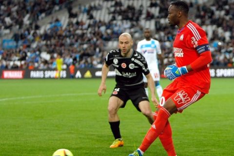 Marseille's French goalkeeper Steve Mandanda, right, challenges for the ball with Reims'midfielder Jaba Kankava, during the League One soccer match between Marseille and Reims, at the Velodrome Stadium, in Marseille, southern France, Saturday, May 7, 2016. (AP Photo/Claude Paris)