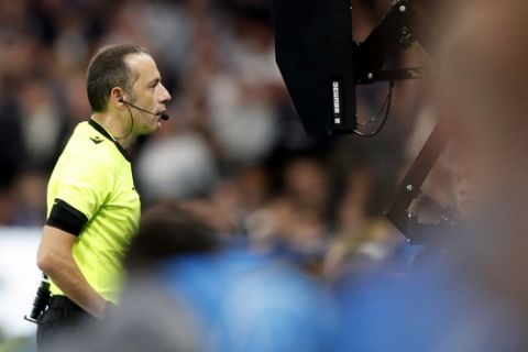 Referee Cuneyt Cakir watches the VAR monitor during the Champions League Group H soccer match between Chelsea and Valencia at Stamford Bridge stadium in London, Tuesday, Sept. 17, 2019. (AP Photo/Frank Augstein)