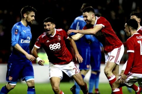 Nottingham Forest's Eric Lichaj, center, celebrates scoring his side's second goal of the game during the English FA Cup, Third Round soccer match between Nottingham Forest and Arsenal at the City Ground, Nottingham, England, Sunday, Jan. 7, 2018. (Mike Egerton/PA via AP)
