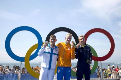 Gold medalist Ferry Weertman, of the Netherlands, center, poses for photos with silver medalist Spyridon Gianniotis, of Greece, left, and bronze medalist Marc-Antoine Olivier, of France, after the men's marathon swimming competition at the 2016 Summer Olympics in Rio de Janeiro, Brazil, Tuesday, Aug. 16, 2016. (AP Photo/Felipe Dana)
