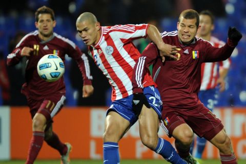 Paraguayan defender Dario Veron (C) fights for the ball with Venezuelan forward Alejandro Moreno (R) as Venezuelan midfielder Cesar Gonzalez (L) approaches, during the 2011 Copa America semi-final football match, at the Malvinas Argentinas stadium in Mendoza, 1058 Km west of Buenos Aires, on July 20, 2011.    AFP PHOTO / Ronaldo Schemidt (Photo credit should read Ronaldo Schemidt/AFP/Getty Images)