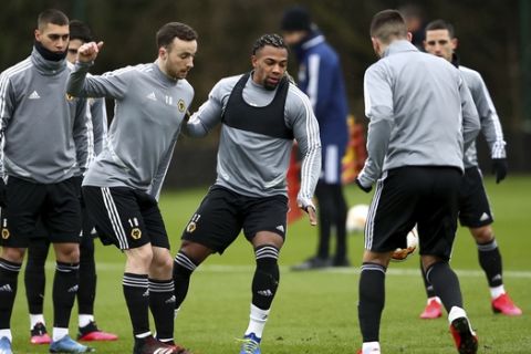 Wolverhampton Wanderers' Adama Traore, centre, and Diogo Jota, centre-left, during the team training session at the Sir Jack Hayward Training Ground in Wolverhampton, England, Wednesday Feb. 19, 2020. Wolves face Espanyol in a Europa League round of 32 first leg soccer match upcoming Thursday. (Tim Goode/PA via AP)