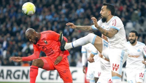 Caen's midfielder Baissama Sankoh, left, challenges for the ball with Marseille's Konstantinos Mitroglou during the League One soccer match between Marseille and Caen, at the Velodrome stadium, in Marseille, southern France, Sunday, Nov. 5, 2017. (AP Photo/Claude Paris)