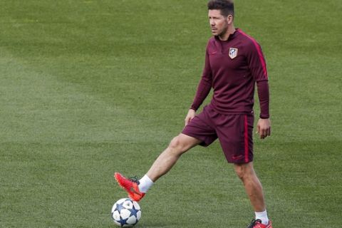 Atletico de Madrid head coach Diego Pablo Simeone plays with a ball during a training session ahead of Wednesday's Champions League semifinal, 2nd leg soccer match between Atletico de Madrid and Real Madrid, in Madrid, Spain, Tuesday, May 9, 2017 . (AP Photo/Daniel Ochoa de Olza)