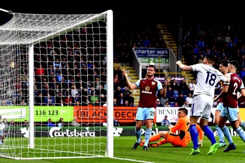 Burnley's Kevin Long, centre, reacts after scoring an own goal for Chelsea's first goal of the game, during their English Premier League soccer match at Turf Moor, Burnley, England, Thursday April 19, 2018.(Anthony Devlin/PA via AP)