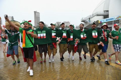 NATAL, BRAZIL - JUNE 13:  A group of Mexico fans cheer in the rain before the 2014 FIFA World Cup Brazil Group A match between Mexico and Cameroon at Estadio das Dunas on June 13, 2014 in Natal, Brazil.  (Photo by Matthias Hangst/Getty Images)