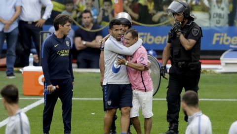 Nahitan Nandez, center, of Argentina's Boca Juniors is embraced by a fan that entered in the field during a training session in Buenos Aires, Argentina Thursday, Nov. 22, 2018. Boca Juniors faces River Plate for the Copa Libertadores soccer final game on Saturday. (AP Photo/Natacha Pisarenko)