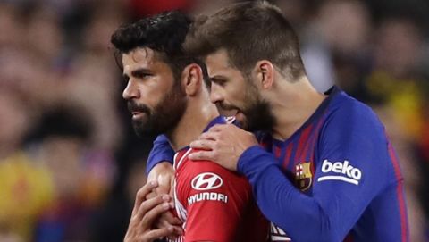 Barcelona's Gerald Pique, right, talks to Atletico forward Diego Costa who was sent off with a red card for insulting referee Jesus Gil Manzano during a Spanish La Liga soccer match between FC Barcelona and Atletico Madrid at the Camp Nou stadium in Barcelona, Spain, Saturday April 6, 2019. (AP Photo/Manu Fernandez)