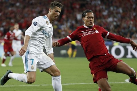 Real Madrid's Cristiano Ronaldo vies for the ball with Liverpool's Virgil Van Dijk during the Champions League Final soccer match between Real Madrid and Liverpool at the Olimpiyskiy Stadium in Kiev, Ukraine, Saturday, May 26, 2018. (AP Photo/Pavel Golovkin)
