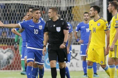 Cyprus' Pieros Sotiriou, left, argues with referee Craig Pawson during the Euro 2020 group I qualifying soccer match between Kazakhstan and Cyprus at the Astana Arena stadium in Nur-Sultan, Kazakhstan, Thursday, Oct. 10, 2019. (AP Photo)