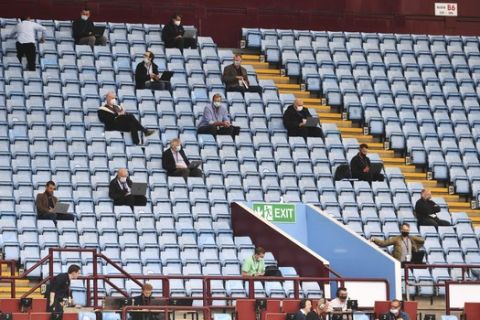 Journalists sit on the tribune prior to the start of the English Premier League soccer match between Aston Villa and Sheffield United at Villa Park in Birmingham, England, Wednesday, June 17, 2020. The English Premier League resumes Wednesday after its three-month suspension because of the coronavirus outbreak. (Paul Ellis/Pool via AP)