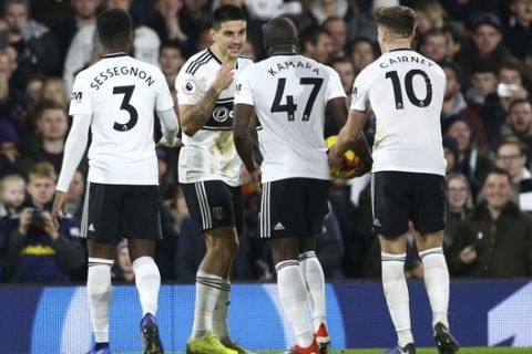 Fulham's Aboubakar Kamara, centre right, and Aleksandar Mitrovic, centre left, seem to disagree over who will take a penalty, during the match against Huddersfield Town, during their English Premier League soccer match at Craven Cottage in London, Saturday Dec. 29, 2018. (Yui Mok/PA via AP)