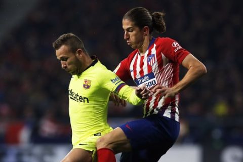 Atletico's Filipe Luis fights for the ball with Barcelona's Arthur, left, during a Spanish La Liga soccer match between Atletico Madrid and FC Barcelona at the Metropolitano stadium in Madrid, Saturday, Nov. 24, 2018. (AP Photo/Paul White)