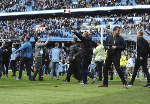 Manchester City fans invade the pitch after winning the English Premier League soccer match between Manchester City and Swansea City 5-0 at Etihad stadium in Manchester, England, Sunday, April 22, 2018. (AP Photo/Rui Vieira)