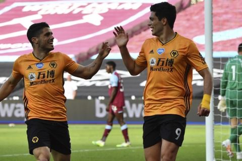 Wolverhampton Wanderers' Raul Jimene, right, celebrates with his teammate Pedro Neto after scoring his side's first goal during the English Premier League soccer match between West Ham and Wolverhampton at London stadium in London, England, Saturday, June 20, 2020. (Ben Stansall/Pool via AP)