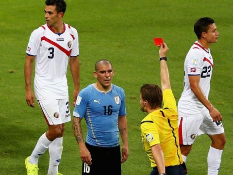 FORTALEZA, BRAZIL - JUNE 14:  Maximilliano Pereira of Uruguay is shown a red card by referee Felix Brych after a foul during the 2014 FIFA World Cup Brazil Group D match between Uruguay and Costa Rica at Castelao on June 14, 2014 in Fortaleza, Brazil.  (Photo by Michael Steele/Getty Images)