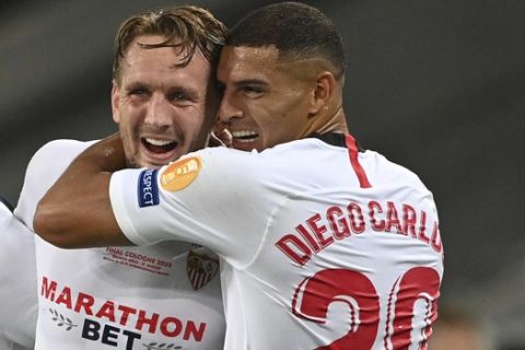 Sevilla's Luuk de Jong, left, celebrates with Sevilla's Diego Carlos after scoring his side's second goal during the Europa League final soccer match between Sevilla and Inter Milan in Cologne, Germany, Friday, Aug. 21, 2020. (Ina Fassbender/Pool via AP)