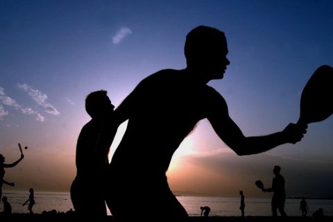 ÁÈÇÍÁ - ÇËÉÏÂÁÓÉËÅÌÁ ÓÅ ÐÁÑÁËÉÁ ÔÇÓ ÃËÕÖÁÄÁÓ
Bathers are silhouetted while playing rackets at the beach of Glyfada, south of Athens on late Wednesday, May 14, 2003, as the sun sets. (AP Photos/Petros Giannakouris)