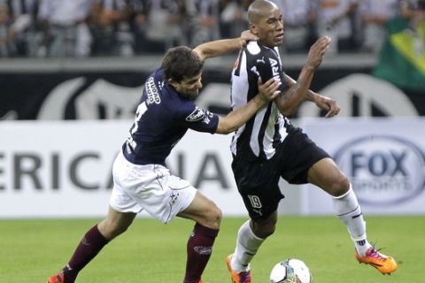 Carlos Araujo of Argentinas Lanus, left, fights for the ball against Emerson of Brazils Atletico Mineiro during the Recopa Sudamericana final soccer match in Belo Horizonte, Brazil, Wednesday, July 23, 2014. (AP Photo/Bruno Magalhaes)