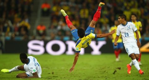 CURITIBA, BRAZIL - JUNE 20: Jefferson Montero of Ecuador falls after a challenge by Maynor Figueroa of Honduras during the 2014 FIFA World Cup Brazil Group E match between Honduras and Ecuador at Arena da Baixada on June 20, 2014 in Curitiba, Brazil.  (Photo by Clive Rose/Getty Images)