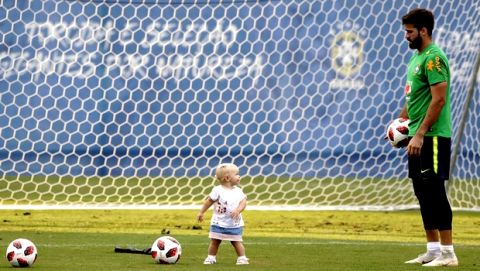 Brazil goalkeeper Alisson plays with his daughter Helena during a training session, in Sochi, Russia, Tuesday, July 3, 2018. Brazil will face Belgium on July 6 in the quarterfinals for the soccer World Cup. (AP Photo/Andre Penner)
