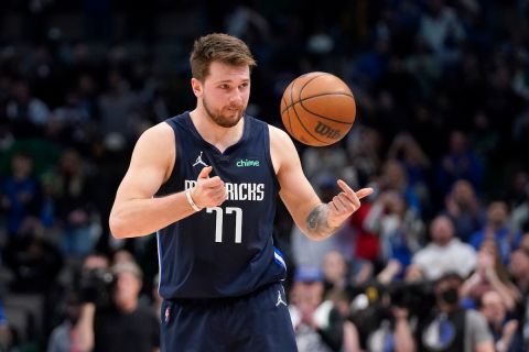 Dallas Mavericks guard Luka Doncic flips the ball to an official at the end of their NBA basketball game against the Utah Jazz in Dallas, Monday, March, 7, 2022. (AP Photo/Tony Gutierrez)