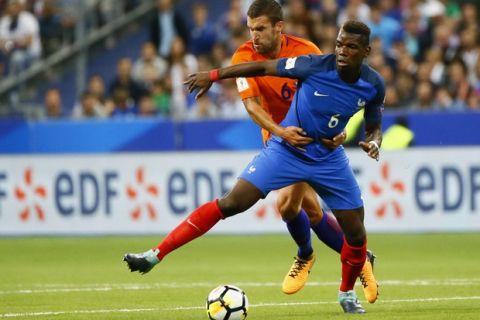 France's Paul Pogba, right, challenges for the ball with Netherlands' Kevin Strootman during the World Cup Group A qualifying soccer match between France and The Netherlands at the Stade de France stadium in Saint-Denis, outside Paris, Thursday, Aug.31, 2017. (AP Photo/Francois Mori)