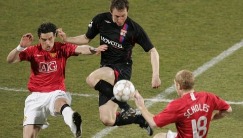 Lyon's Kim Kallstrom, center, challenges for the ball with Manchester United's Owen Hargreaves, left, and Paul Scholes, right, during their Champions League round of 16 soccer match at Gerland Stadium, in Lyon, central France, Wednesday, Feb. 20, 2008. (AP Photo/Laurent Cipriani)