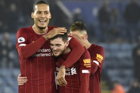 Liverpool's Virgil van Dijk, Liverpool's Andrew Robertson, centre, and Liverpool's Roberto Firmino, right, celebrate their victory at the end of the English Premier League soccer match between Leicester City and Liverpool at the King Power Stadium in Leicester, England, Thursday, Dec. 26, 2019. (AP Photo/Rui Vieira)