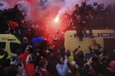 Soccer fans light flares and clamber atop Police vans before their Champions League, Semi Final First Leg soccer match at Anfield in Liverpool, England, Tuesday April 24, 2018. (Peter Byrne/PA via AP)