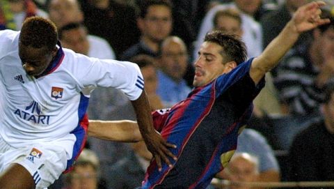 Barcelona's Francesco Coco, right, battles for the ball with Olympique's Sidney Govou during their Champions League match in Barcelona, Spain, Wednesday Oct. 10, 2001.  Barcelona won the game 2-0. (AP Photo/Cesar Rangel)