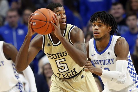 Georgia Tech's Moses Wright, center, looks for an opening on Kentucky's Keion Brooks Jr., right, and Kahlil Whitney, left, during the first half of an NCAA college basketball game in Lexington, Ky., Saturday, Dec. 14, 2019. (AP Photo/James Crisp)