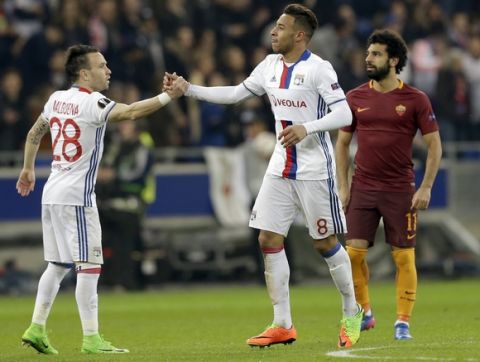 Lyon's Corentin Tolisso, center, is congratulated by his teammate Mathieu Valbuena after scoring his side's 2nd goal while Roma's Mohamed Salah looks on during a Europa League round of 16 first leg soccer match between Lyon and Roma in Decines, near Lyon, central France, Thursday, March 9, 2017. (AP Photo/Claude Paris)