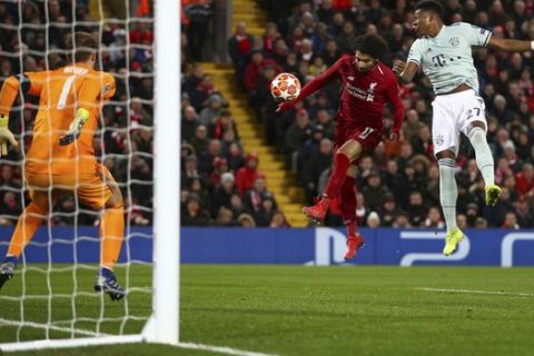 Liverpool's Mohamed Salah, center, fails to score a header past Bayern goalkeeper Manuel Neuer, left, and Bayern defender David Alaba during the Champions League round of 16 first leg soccer match between Liverpool and Bayern Munich at Anfield stadium in Liverpool, England, Tuesday, Feb. 19, 2019. (AP Photo/Dave Thompson)