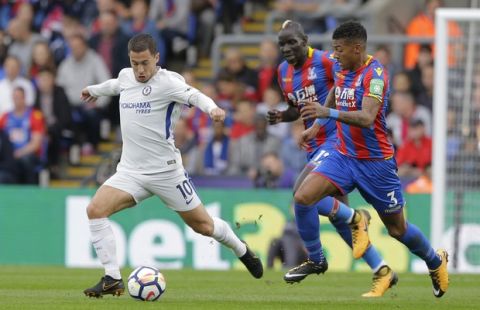 Chelsea's Eden Hazard, left, takes the ball forward and away from Crystal Palace's Patrick Van Aanholt, right, during the English Premier League soccer match between Crystal Palace and Chelsea at Selhurst Park stadium in London Saturday, Oct 14 2017. (AP Photo/Alastair Grant)