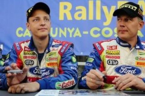 Finland's driver Mikko Hirvonen, left, and and co-driver Jarmo Lehtinen sign autographs before the Rally of Catalonia in Salou, Spain, Thursday, Oct. 1, 2009. (AP Photo/Manu Fernandez)