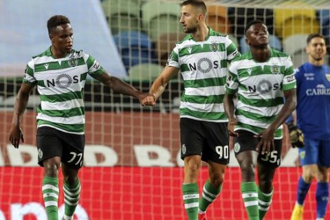 Sporting's Sporar celebrates with teammate Jovane Cabral, left, after scoring his side's second goal during the Portuguese League soccer match between Sporting CP and Tondela at the Jose Alvalade stadium in Lisbon, Portugal, Thursday, June 18, 2020. The Portuguese League soccer matches are being played without spectators because of the coronavirus pandemic. (Miguel A. Lopes/Pool via AP)
