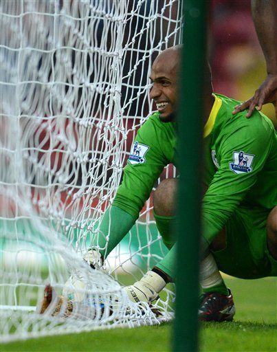 Wigan's goalkeeper Ali Al-Habsi holds a chicken placed by Blackburn protestors against the owners of the club during Blackburn's English Premier League soccer match against Wigan at Ewood Park Stadium, Blackburn, England, Monday May 7, 2011. (AP Photo/Jon Super)
