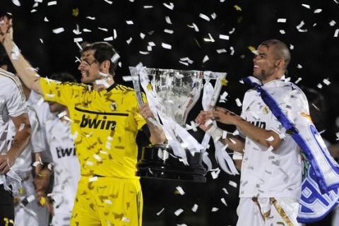 Real Madrid's goalkeeper Iker Casillas and team-mate Pepe (R) hold the Spanish league first division trophy at Santiago Bernabeu stadium in Madrid after their Spain's First Division soccer match against Real Mallorca, May 13, 2012. Real Madrid won the Spanish first division 2012 league title at San Mames stadium in Bilbao on May 2 which is the club's first La Liga title in four years.  REUTERS/Ricardo Ordonez (SPAIN - Tags: SPORT SOCCER)