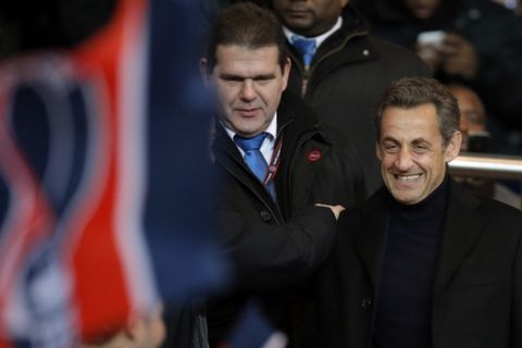 Former French President Nicolas Sarkozy, right, attends the League One soccer match between Paris Saint Germain and Montpellier at Parc des Princes Stadium, in Paris, Friday March 29, 2013. (AP Photo/Francois Mori)