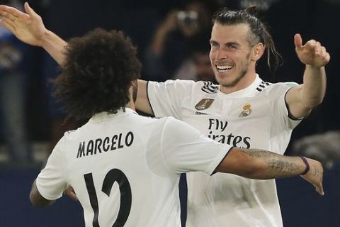 Real Madrid's midfielder Gareth Bale celebrates with teammate Marcelo, left, after scoring his side's third goal during the Club World Cup semifinal soccer match between Real Madrid and Kashima Antlers at Zayed Sports City stadium in Abu Dhabi, United Arab Emirates, Wednesday, Dec. 19, 2018. (AP Photo/Kamran Jebreili)