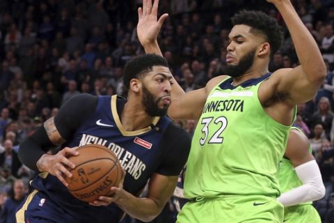 New Orleans Pelicans' Anthony Davis, left, drives as Minnesota Timberwolves' Karl-Anthony Towns defends in the second half of an NBA basketball game Saturday, Jan. 12, 2019, in Minneapolis. (AP Photo/Jim Mone)