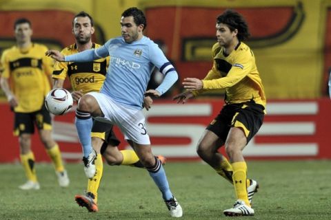 Carlos Tevez of Manchester City (L) fights for the ball with Juan Toja of Aris during their Round of 32 Europa League football match Aris Thessaloniki vs Manchester City at the Kleanthis Vikelidis stadium in Thessaloniki, on February 15, 2011. AFP PHOTO ARIS MESSINIS (Photo credit should read ARIS MESSINIS/AFP/Getty Images)