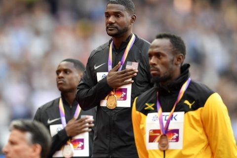 Men's 100 meters gold medalist Justin Gatlin, centre, stands with compatriot and silver medalist Christian Coleman, left, and bronze medalist Jamaica's Usain Bolt on the podium the medal ceremony at the World Athletics Championships in London Sunday, Aug. 6, 2017. (AP Photo/Martin Meissner)