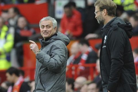 Manchester United coach Jose Mourinho, left, and Liverpool coach Juergen Klopp react on the sidelines during the English Premier League soccer match between Manchester United and Liverpool at Old Trafford in Manchester, England, Saturday, March 10, 2018. (AP Photo/Rui Vieira)