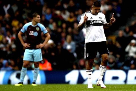 Fulham's Aleksandar Mitrovic, right, celebrates scoring his side's second goal of the game as Burnley's James Tarkowski appears dejected during their English Premier League soccer match at Craven Cottage, London, Sunday, Aug. 26, 2018. (John Walton/PA via AP)