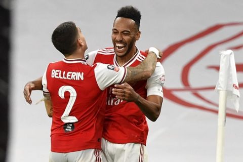 Arsenal's Pierre-Emerick Aubameyang celebrates with teammate Hector Bellerin, left, after scoring his team's second goal during the FA Cup semifinal soccer match between Arsenal and Manchester City at Wembley in London, England, Saturday, July 18, 2020. (AP Photo/Justin Tallis,Pool)