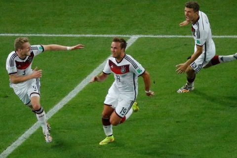 RIO DE JANEIRO, BRAZIL - JULY 13:  Mario Goetze of Germany (C) celebrates scoring his team's first goal in extra time with teammates Andre Schuerrle (L) and Mesut Oezil during the 2014 FIFA World Cup Brazil Final match between Germany and Argentina at Maracana on July 13, 2014 in Rio de Janeiro, Brazil.  (Photo by Pool/Getty Images)