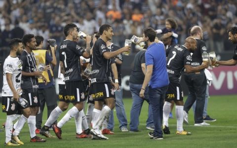 Corinthians players carry drinks as they celebrate clenching the Brasileirao soccer championship title, after their 3-1 victory over Fluminense in Sao Paulo, Brazil, Wednesday, Nov. 15, 2017. (AP Photo/Andre Penner)