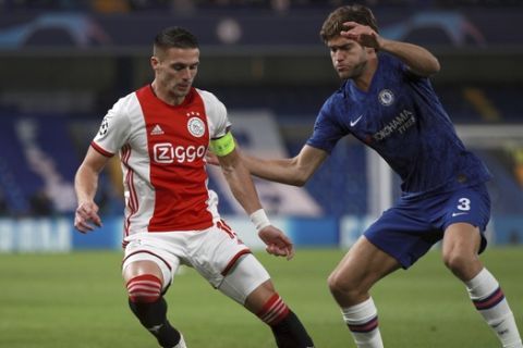 Ajax's Dusan Tadic, left, duels for the ball with Chelsea's Marcos Alonso during the Champions League, group H, soccer match between Chelsea and Ajax, at Stamford Bridge in London, Tuesday, Nov. 5, 2019. (AP Photo/Ian Walton)